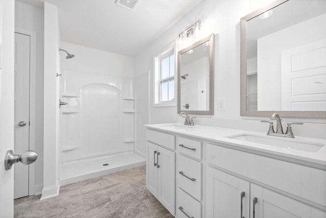 bathroom featuring a shower and vanity