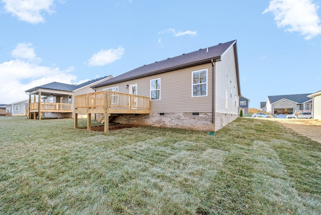 back of property featuring a wooden deck and a lawn