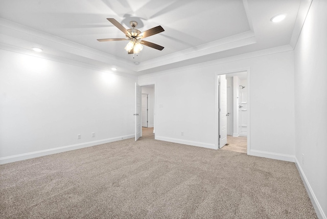 carpeted spare room featuring ceiling fan, a tray ceiling, and crown molding