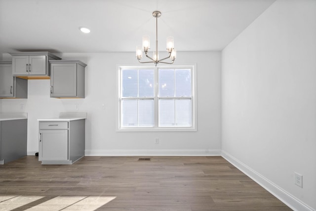 unfurnished dining area featuring light hardwood / wood-style floors, a wealth of natural light, and a chandelier