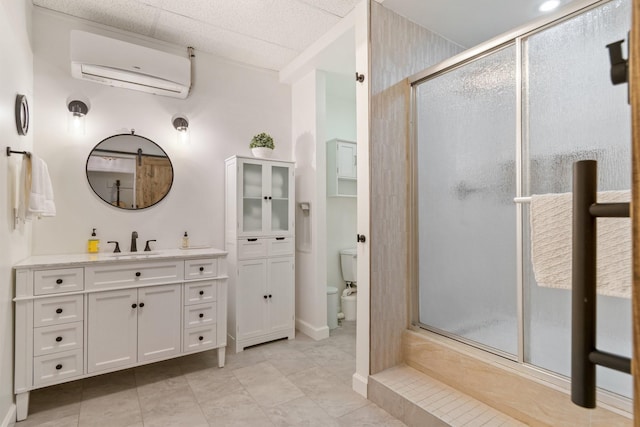 bathroom featuring tile patterned floors, toilet, a wall mounted air conditioner, a shower with shower door, and vanity