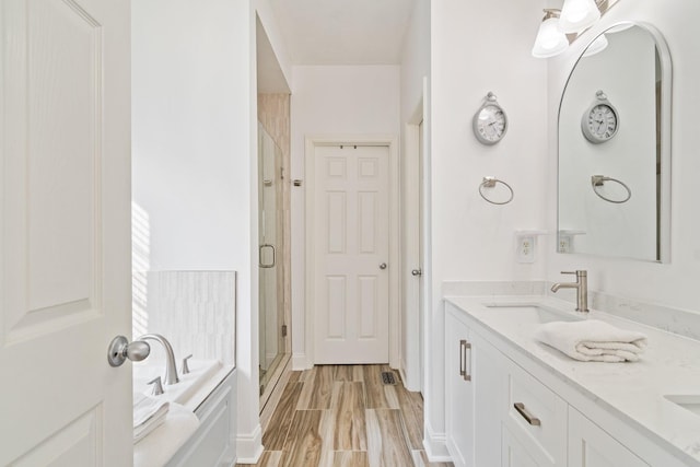 bathroom featuring hardwood / wood-style floors, vanity, and shower with separate bathtub