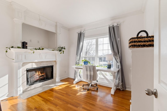 office area with hardwood / wood-style floors, a fireplace, and crown molding