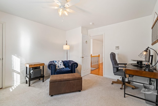 carpeted home office featuring ceiling fan