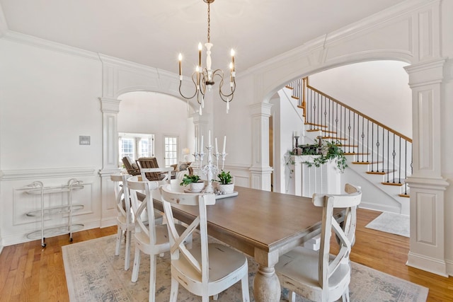 dining area with a notable chandelier, crown molding, and light hardwood / wood-style floors