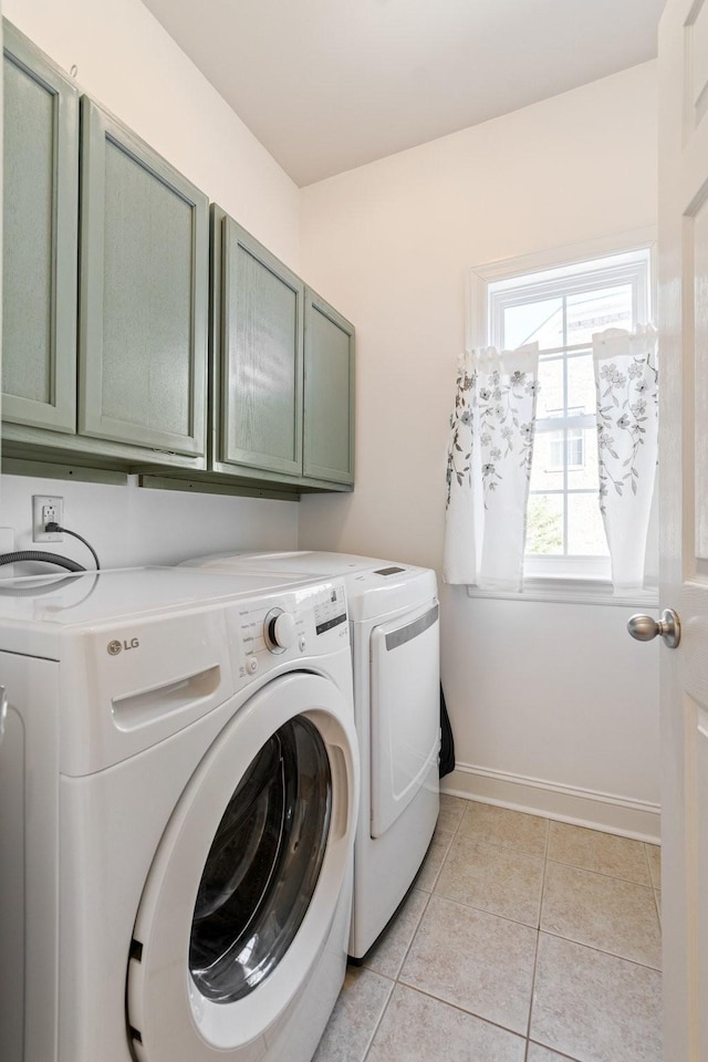 laundry room featuring cabinets, washer and dryer, and light tile patterned floors