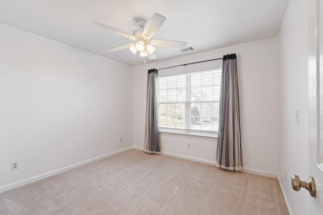 empty room featuring ceiling fan and light carpet