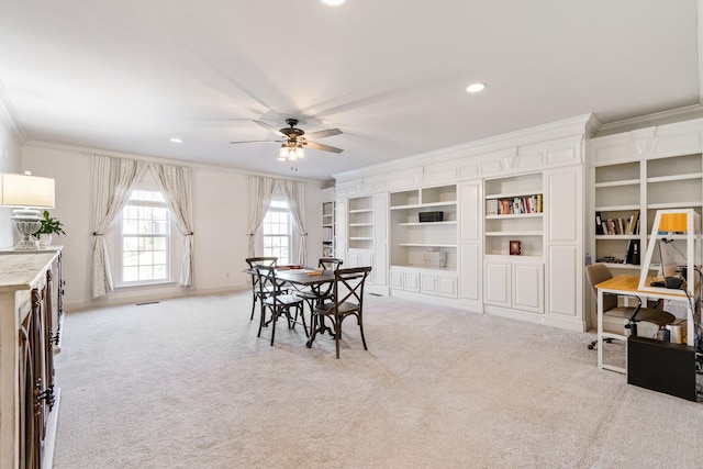 dining room with crown molding, ceiling fan, and light carpet