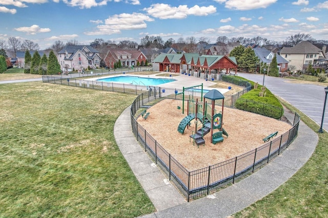 view of swimming pool with a playground and a yard