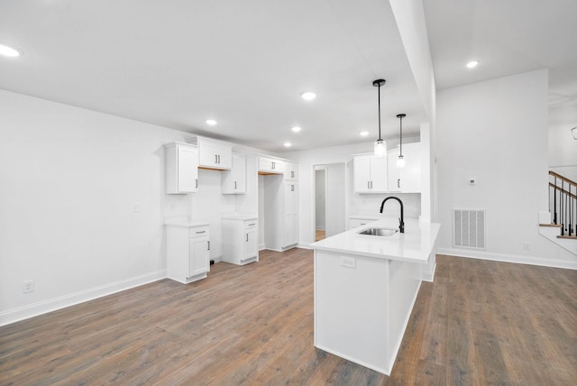 kitchen featuring decorative light fixtures, sink, white cabinets, and dark hardwood / wood-style floors