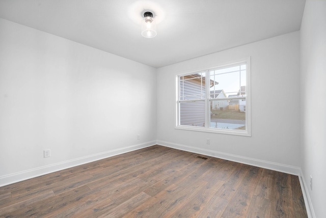 unfurnished room with dark hardwood / wood-style floors