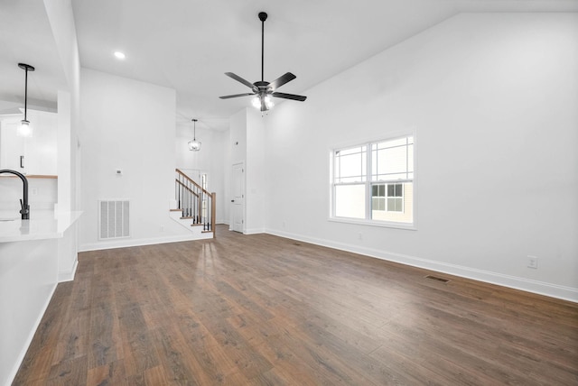 unfurnished living room with ceiling fan, sink, dark hardwood / wood-style flooring, and lofted ceiling