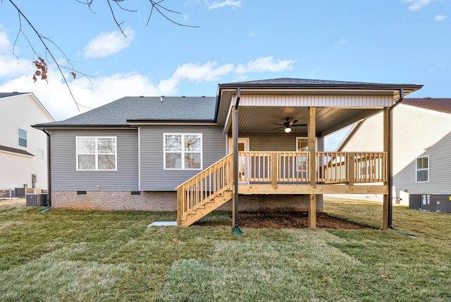 back of property with a lawn, ceiling fan, and a wooden deck