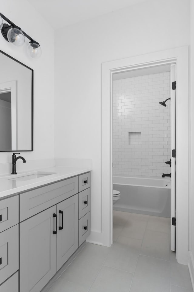 full bathroom featuring toilet, tile patterned floors, vanity, and tiled shower / bath combo