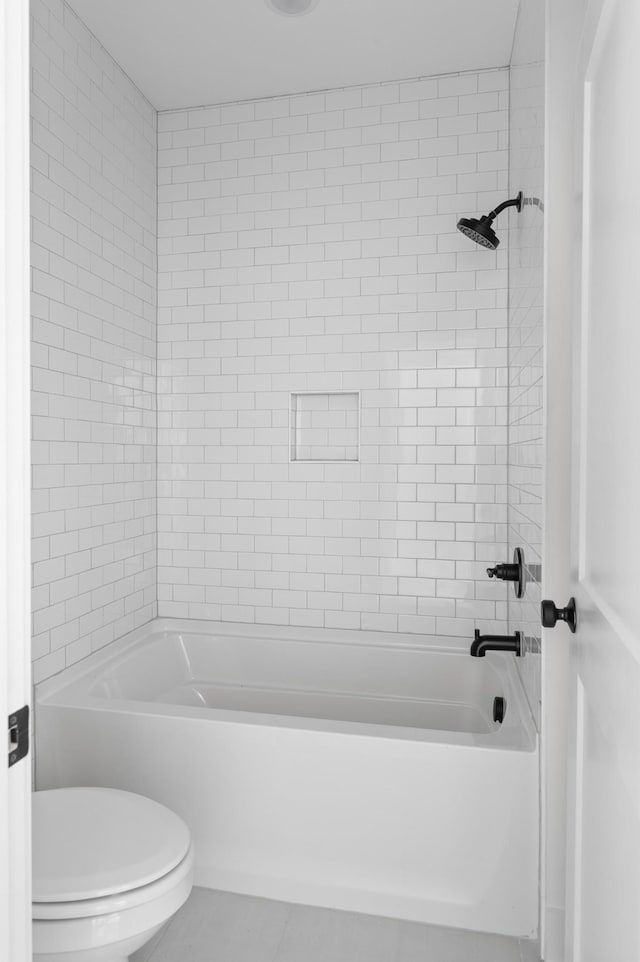 bathroom featuring toilet, tile patterned floors, and washtub / shower combination