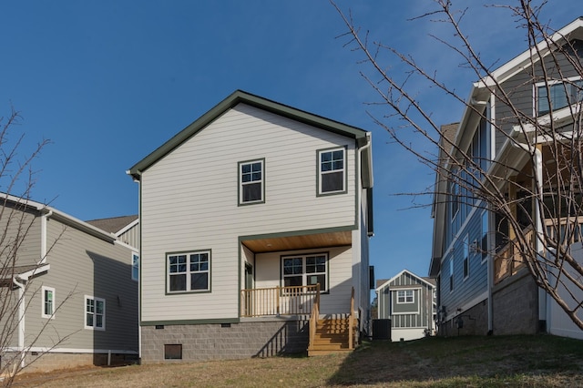 back of house featuring covered porch, central air condition unit, and a storage shed