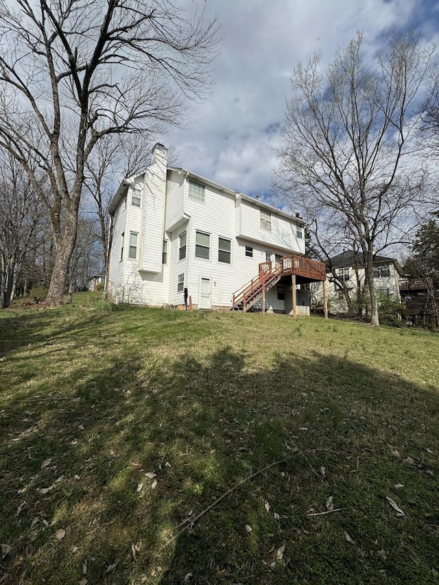 back of house featuring a lawn and a wooden deck