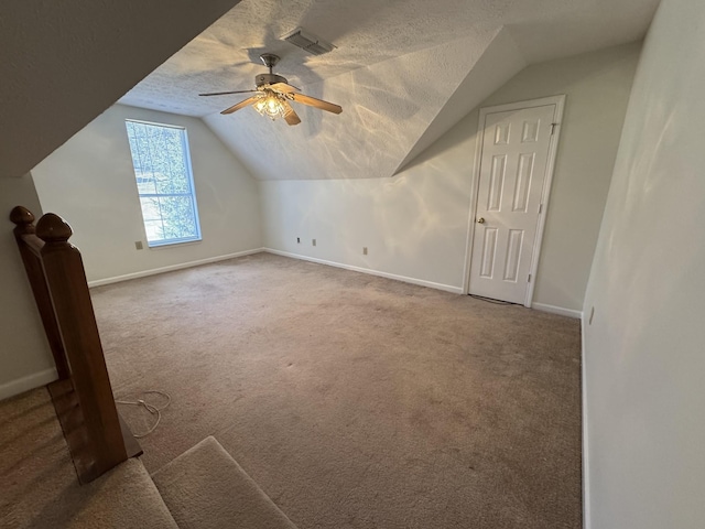 additional living space with ceiling fan, a textured ceiling, carpet, and lofted ceiling