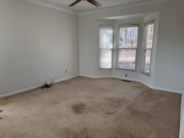 spare room with light carpet, a healthy amount of sunlight, ceiling fan, and ornamental molding