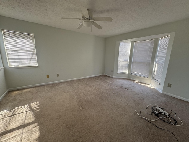 unfurnished room with ceiling fan, light colored carpet, and a textured ceiling