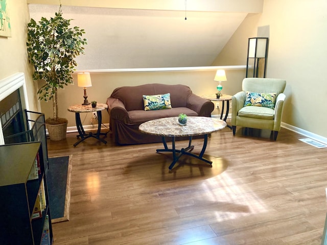 living room featuring hardwood / wood-style flooring and vaulted ceiling