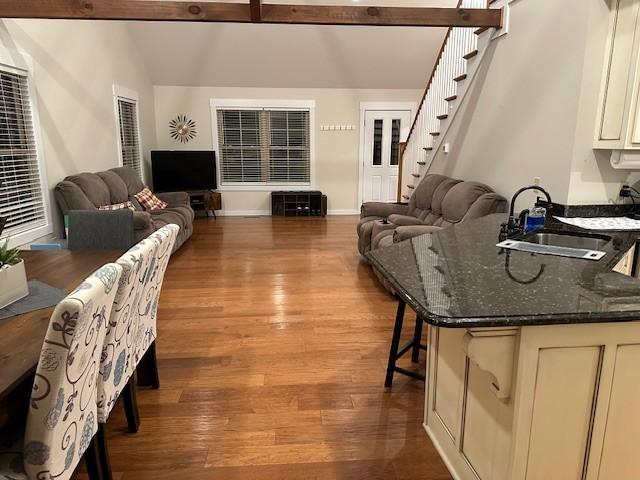 living room featuring sink, hardwood / wood-style floors, and beam ceiling