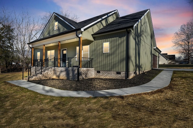 view of front of house featuring a yard, a porch, and a garage