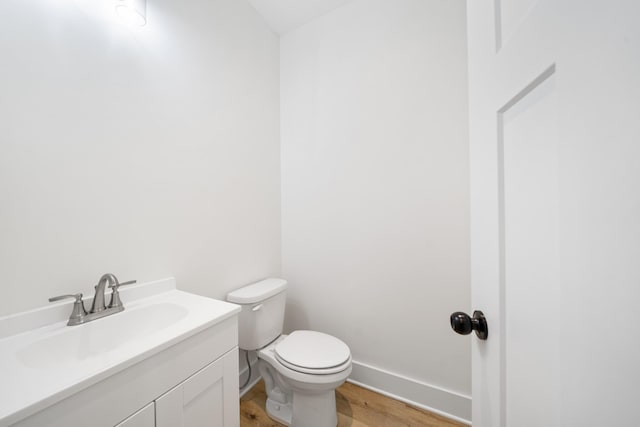 bathroom featuring toilet, vanity, and hardwood / wood-style floors