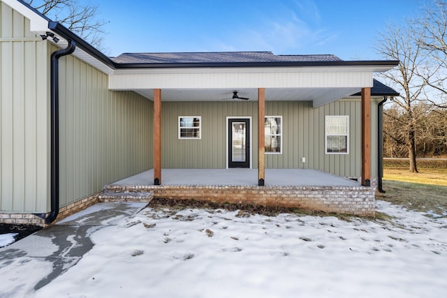 snow covered property entrance featuring covered porch