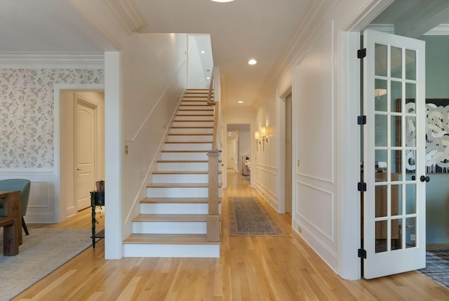 staircase with hardwood / wood-style flooring and ornamental molding