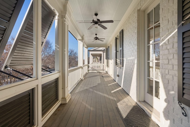 wooden terrace with ceiling fan and covered porch