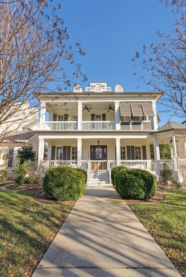 exterior space featuring a front yard, ceiling fan, a porch, and a balcony