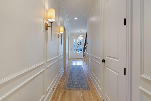 hall with crown molding and light wood-type flooring