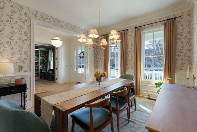 dining room featuring light wood-type flooring, crown molding, and an inviting chandelier