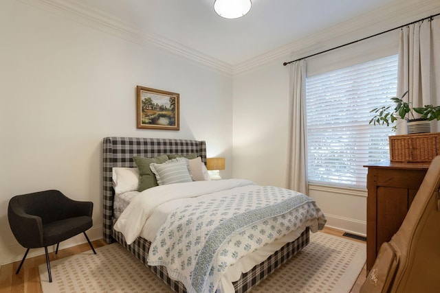 bedroom featuring light hardwood / wood-style floors and crown molding