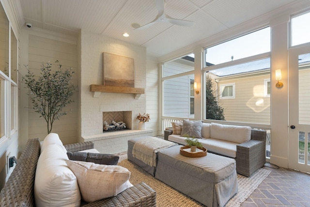 living room featuring a brick fireplace, ceiling fan, and a healthy amount of sunlight