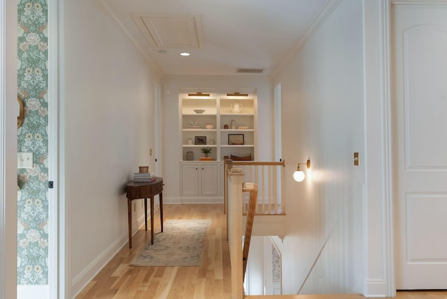 hall featuring built in features, crown molding, and light hardwood / wood-style floors