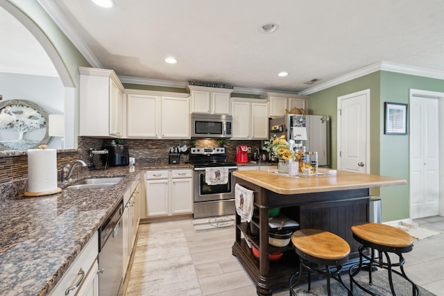 kitchen featuring decorative backsplash, sink, appliances with stainless steel finishes, and crown molding