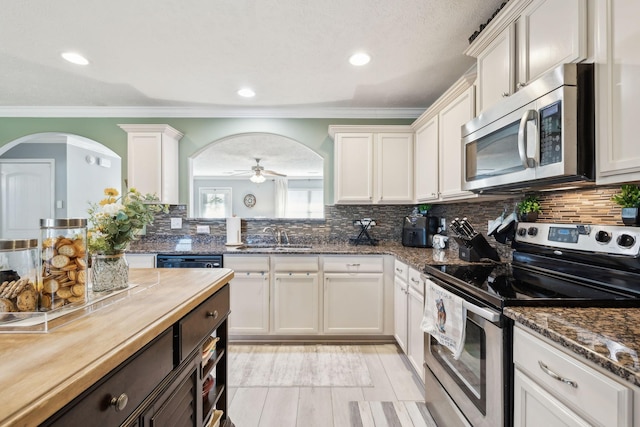 kitchen with ceiling fan, sink, white cabinetry, and stainless steel appliances