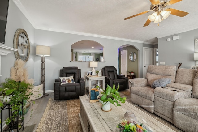 living room with hardwood / wood-style flooring, a textured ceiling, crown molding, and ceiling fan