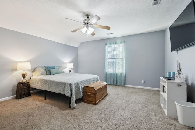 bedroom with a textured ceiling, light colored carpet, vaulted ceiling, and ceiling fan