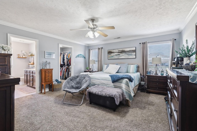 bedroom with ceiling fan, multiple windows, light colored carpet, and a spacious closet