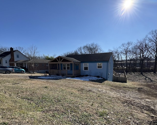 back of property featuring covered porch and a yard