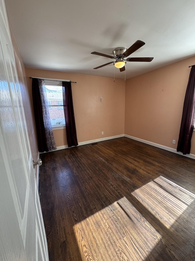 spare room featuring ceiling fan and dark hardwood / wood-style floors