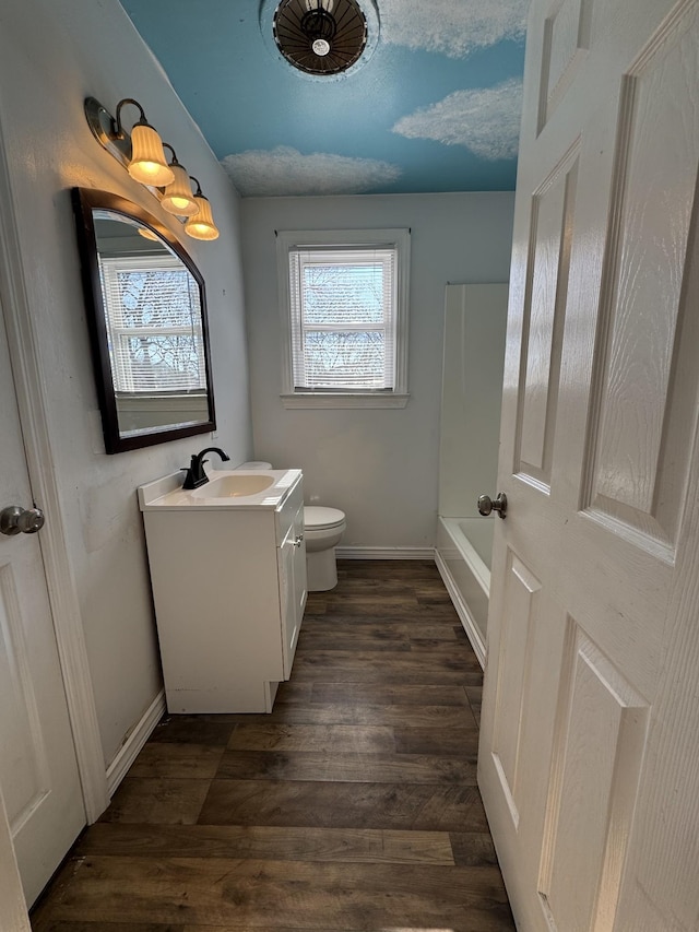 bathroom with hardwood / wood-style flooring, toilet, and vanity