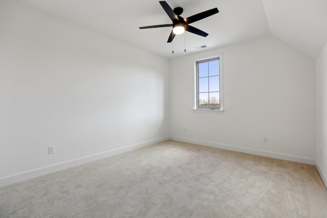 spare room with ceiling fan, lofted ceiling, and light carpet