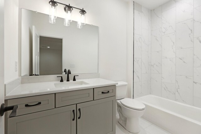 full bathroom featuring tiled shower / bath, vanity, and toilet