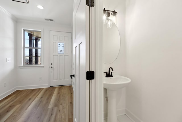 bathroom featuring hardwood / wood-style flooring and ornamental molding