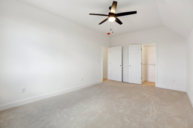 unfurnished bedroom featuring vaulted ceiling, light colored carpet, and ceiling fan