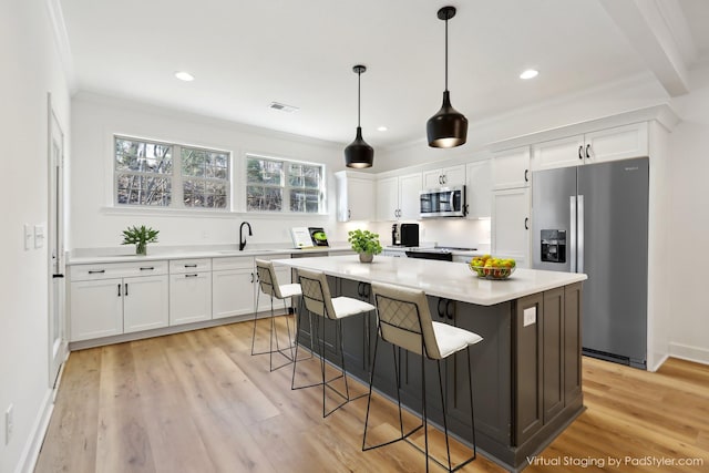 kitchen with stainless steel appliances, a center island, visible vents, and white cabinets